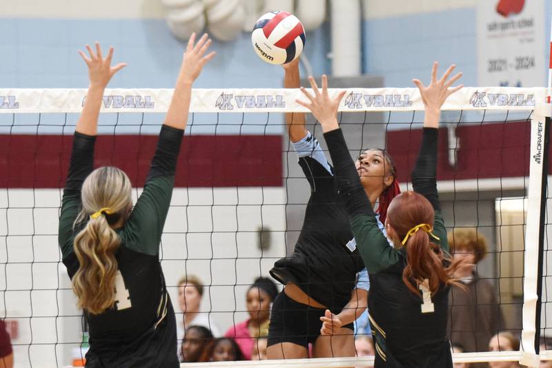 Kankakee's Ki'Asia Wilson, center, sends a hit over the net in between Bishop McNamara's Kate Dole, left, and Montana Reid during an All-City meeting at Kankakee Wednesday, Sept. 3, 2025.