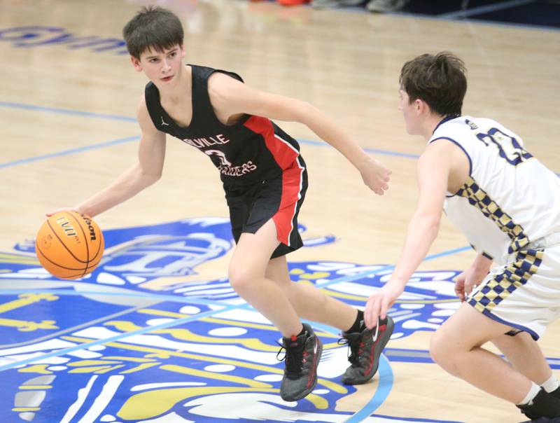Earlville's Gavin Guelde dribbles around Marquette's Griffin Dobberstein on Friday, Jan. 3, 2025 in Bader Gym at Marquette High School.