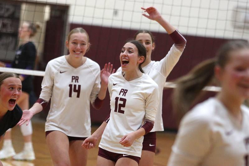Prairie Ridge’s Jada Hoyt, center left, and Julia Reina, center right, celebrate a point against Hampshire during varsity volleyball on Thursday, Oct. 3, 2024, at Prairie Ridge High School in Crystal Lake.