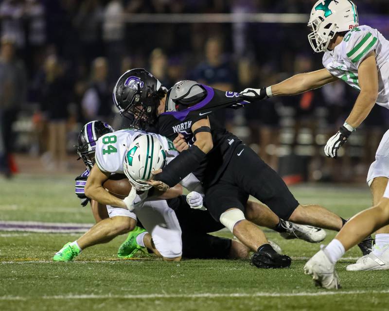 York's Luke Mallander (84) is gang tackled by Downers Grove North's Jimmy Janicki (9) and Joseph Edwards (8) during football game between York at Downers Grove North.  Sept 29, 2023.