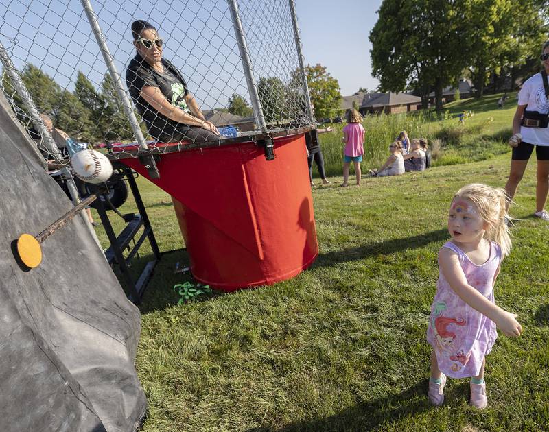Just a bit outside: Brooklyn Clark, 4, fires a pitch looking to dunk Jefferson principal Crystal Thorpe Thursday, Aug. 29, 2024, during the Dixon PTO “Party in the Playground.”
