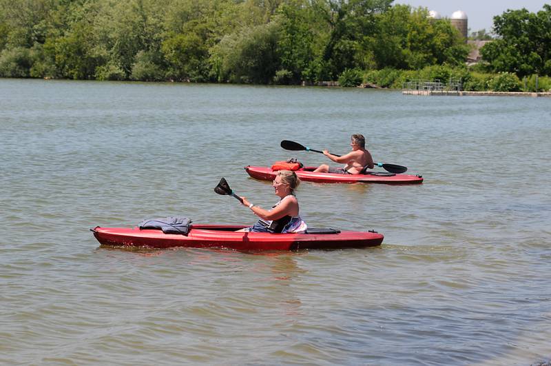 Chris Powers of McHenry and Bill Carson of Cary paddle Tuesday, June 14, 2022, in McCullom Lake as temperatures in the McHenry County area reached the mid-90’s.