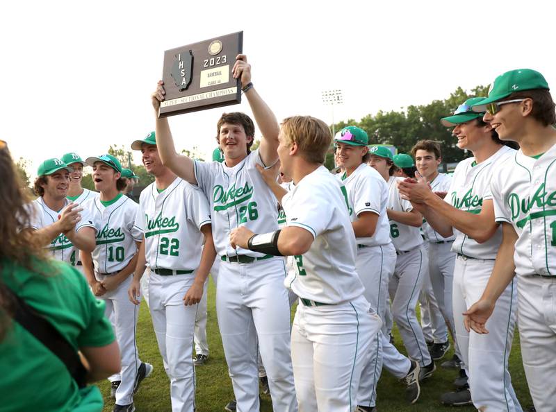 York pitcher Ryan Sloan hoists the trophy following their Class 4A Kane County Supersectional win against Hononegah at Northwestern Medicine Field in Geneva on Monday, June 5, 2023.