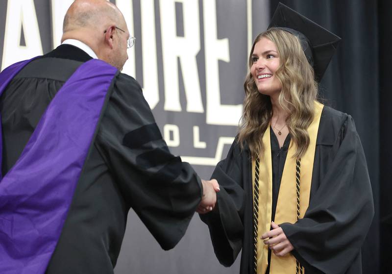 Grace Carey is congratulated by Board of Education President James J. Dombek as she receives her diploma during commencement ceremonies Sunday, May 28, 2023, at Sycamore High School.
