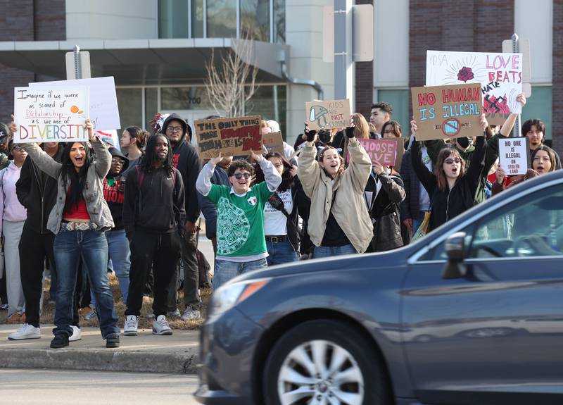 Northern Illinois University students cheer as vehicles passing on Lincoln Highway honk in support Friday, Feb 13, 2026, during a gathering in front of the DeKalb Police Department, to protest against recent nationwide U.S. Immigration and Customs Enforcement activity.
