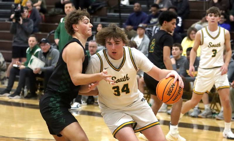 Crystal Lake South’s John Morgan works under the hoop as Waubonsie Valley’s Tyus Payne defends during Hinkle Holiday Classic varsity boys basketball tournament title game action on Friday, Dec. 27, 2024 at Jacobs High School in Algonquin.