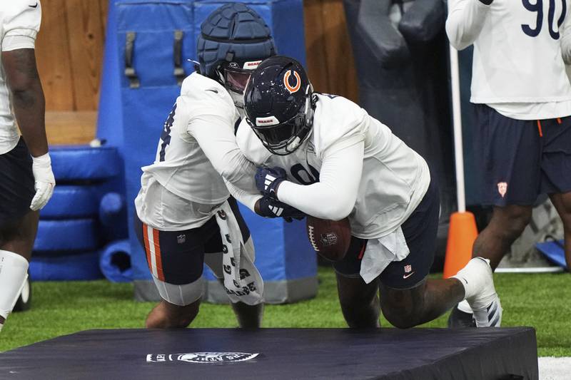 Chicago Bears defensive lines Austin Booker, left, works with Gervon Dexter Sr. during NFL football practice in Lake Forest, Ill., Wednesday, May 21, 2025. (AP Photo/Nam Y. Huh)