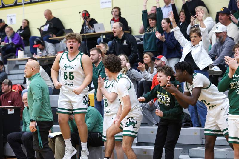 Bishop McNamara's Ian Irps (55) celebrates a dunk by teammate Callaghan O'Connor along with the bench and fans during the Fightin' Irish's 66-52 victory over El Paso-Gridley in the IHSA Class 2A Herscher Regional championship on Friday, Feb. 27, 2026.