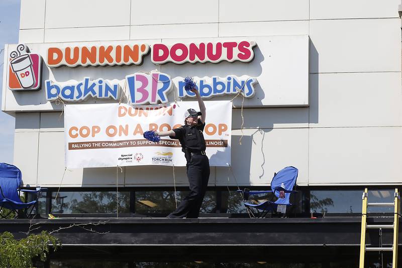 Huntley Police Department Deputy Chief Amy Willams cheers from the roof of a Dunkin’ Donuts, at 12090 Princeton in Huntley, during the Cop on a Rooftop fundraiser to raise awareness for Special Olympics Illinois and the Law Enforcement Torch Run to benefit Special Olympics on Friday, Aug. 19. 2022. Huntley Police Department officers, in support of the Law Enforcement Torch Run for Special Olympics Illinois, took to the roofs and ground around both Huntley Dunkin’ Donuts locations before finishing the day with the sixth annual donut-eating contest. Participants in the contest included representatives from the Police Department, Village of Huntley, Huntley Fire Protection District, Huntley Park District, Consolidated School District 158 and the Huntley Area Chamber of Commerce. This year's winner was Huntley Police Department Sgt. Scott Sullivan.