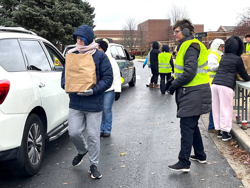 Volunteers deliver bags of food during a community food drive outside the east campus for Lockport Township High School District 205 on Sunday, Nov. 9, 2025.