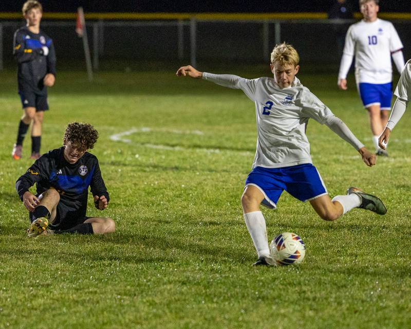 Landon Johnson (20) of Somonauk/Leland/Newark sits on ground after falling as Travis Herrmann (2) of Hinckley-Big Rock kicks ball during the Little Ten Conference Championship match on Thursday, Oct. 9, 2025 at Hinckley-Big Rock School in Hinckley.