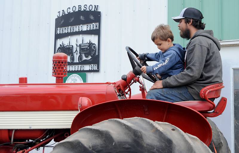 Farmer Bryon Kelly and his son, Rich, 2, move a tractor Friday, June 10, 2022, on the Jacobson farm near Richmond. Kelly inherited the century-old farm from his step-grandfather Richard Jacobson.