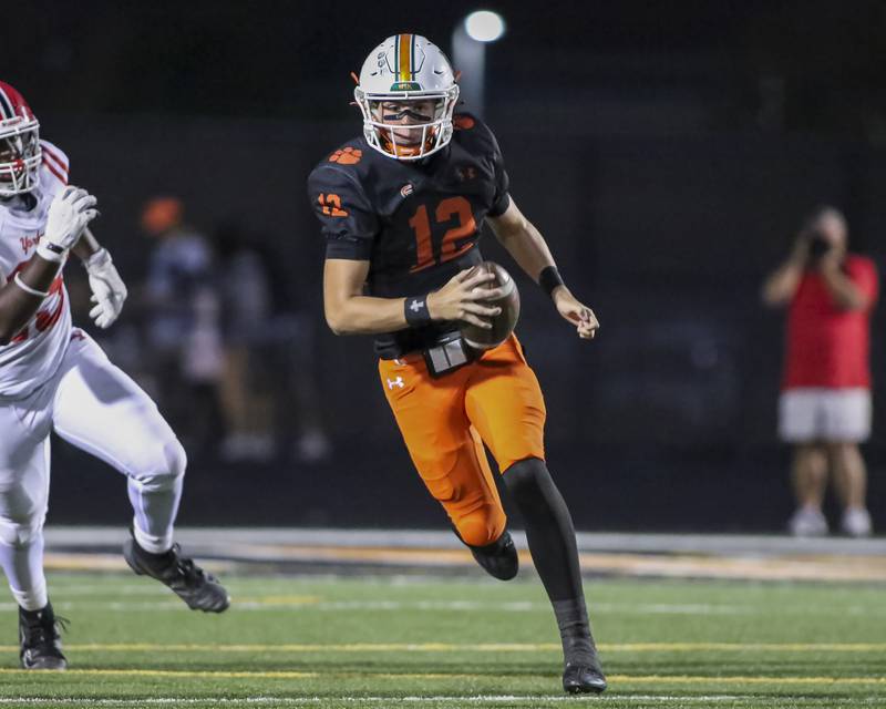 Plainfield East's Brady Cloherty (12) scrambles away from pressure during football game between Yorkville at Plainfield East Friday, Sept 19, 2025 in Plainfield.