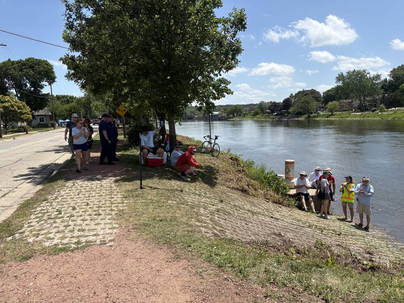 Event personnel and volunteers clap during the "El Cardunal" paddle in East Dundee June 22, 2025.