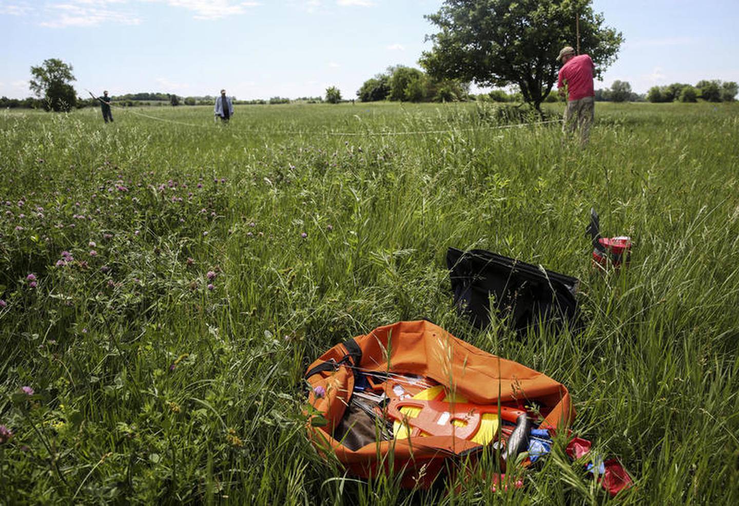 An orange bag of archeological tools sit in the grass May 31 during a survey of an archeological site at the former Joliet Arsenal in Joliet.