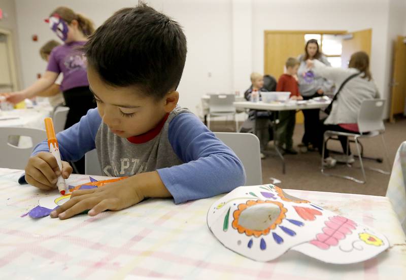 Craig Lunak, 5, colors a mask as children make masks on Wednesday, Oct. 23, 2024, during at Kids Crafternoon at the Harvard Diggins Library. Children were able to chose between several Halloween themed masks to make.