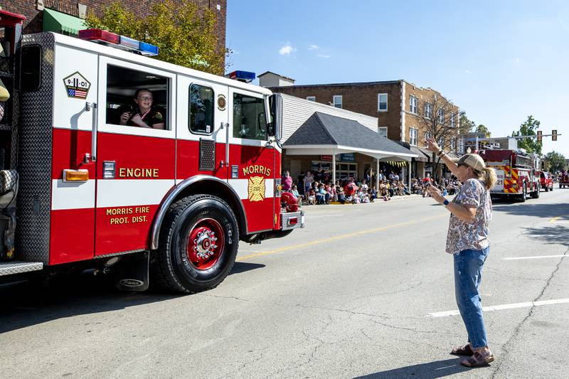 Jody Eschenbaum waves to her daughter and granddaughters who are riding with the Morris Fire Department during the Grundy County Corn Festival Parade in Downtown Morris on Sept. 28, 2025.