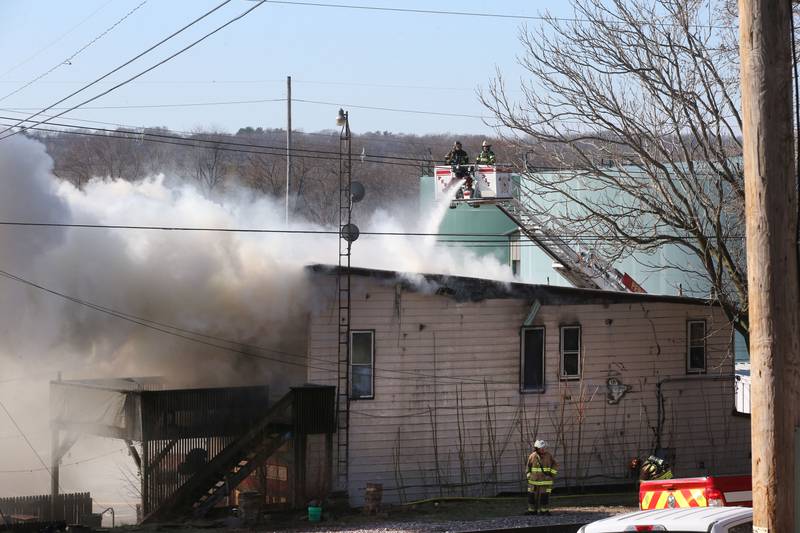 Peru firefighters attack the smoke from their aerial truck during a fire scene at the former Platform 31 tavern on Monday, March 24, 2025 on Water Street in Peru. The fire was upgraded to a three-alarm summing ire departments from La Salle, Utica, Mendota, Tonica, Ottawa, Ladd, Spring Valley, Lostant, Cedar Point, Troy Grove and Peru responded to the fire.
