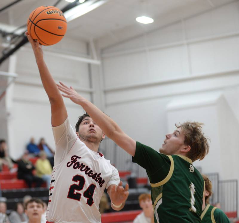 Forreston's Mickey Probst (24) shoots a layup as Peru St. Bede's Kaden Newman (1) tries to get a piece of the ball during Wednesday, Feb. 26, 2025 action at the 1A Amboy Regional at Amboy High School.
