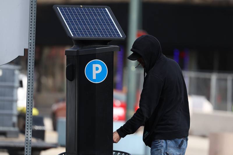 A person pays for parking at the Joliet City Square parking lot in downtown Joliet on Wednesday Mar. 6th, 2024.