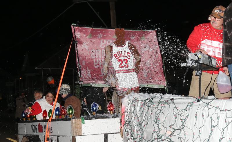 A snow machine blows fake snow on a "Home Alone" themed float during the annual Christmas Parade on Saturday, Dec. 7, 2024 on Peoria Street in Peru.