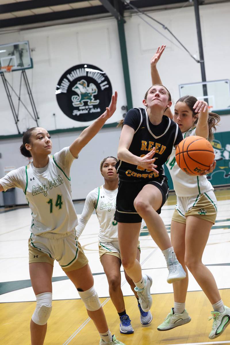 Reed-Custer's Alyssa Wollenzien maneuvers through Bishop McNamara defenders for a layup attempt during Bishop McNamara's 60-36 victory over Reed-Custer in the IHSA Class 2A Bishop McNamara Regional semifinals on Monday, Feb. 16, 2026.
