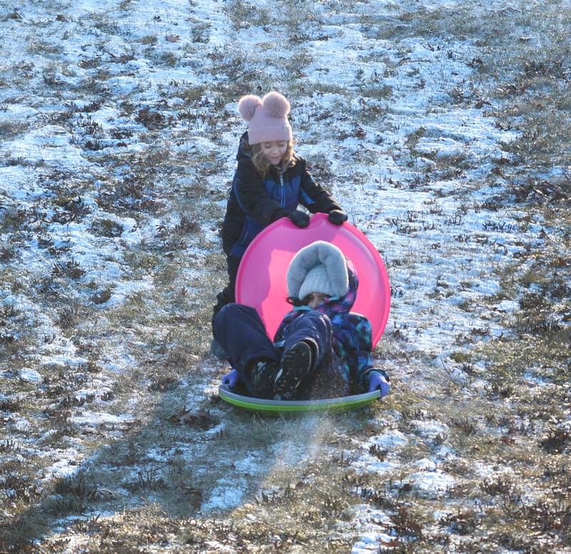 Amari Orellana, 5, of Naples, Florida, holds her saucer sled in front of Eliana Orellana, 11, as they sled down the hill at Winter Park in Morrison on Friday, Jan. 3, 2025. Amari and Eliana and their family were visiting relatives in Morrison and wanted to try sledding following the dusting of snow that fell across the region.