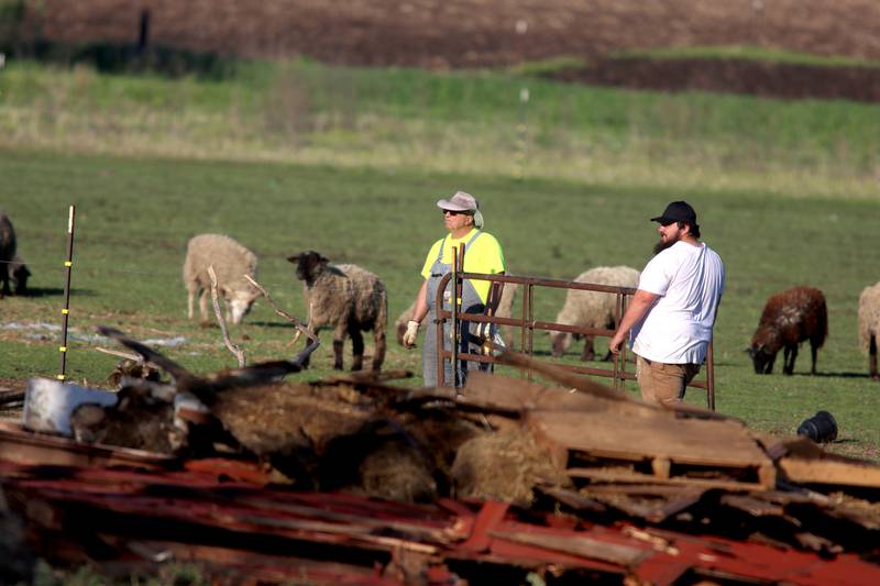 First responders and property owners tend the scene of a barn collapse along Weidner Road near Harvard on Tuesday evening.