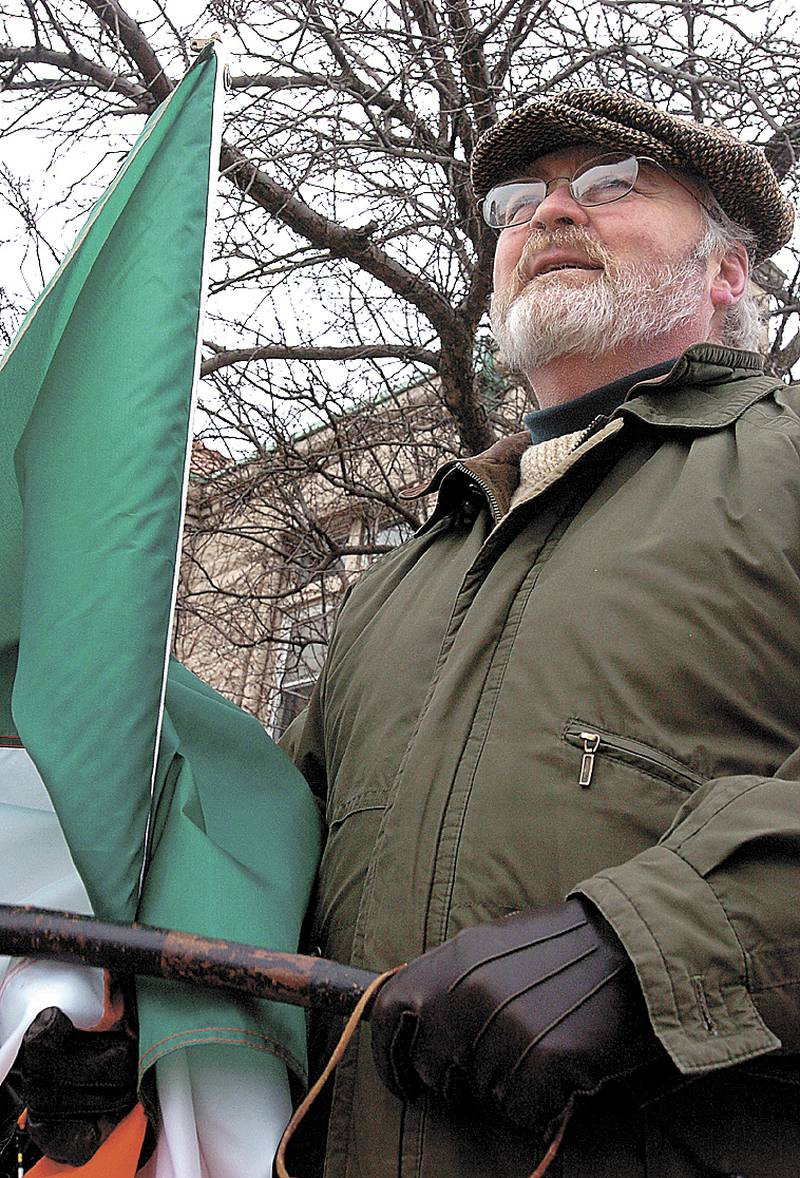 2005 File: With his shillelagh and Irish flag in hand, James Dixon watches the St. Patrick's Day parade go by in Dixon.
