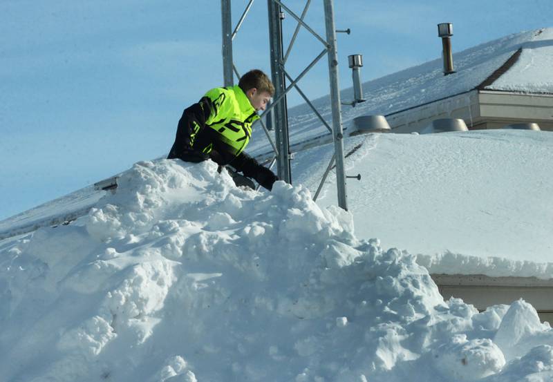 Gage Loomis, 13, climbed to the top of 10-foot large snow pile by the Forreston Library on Monday, Jan. 15, 2024. Ogle County residents and muncipal workers were still busy digging out from Friday and Saturday's winter storm that dropped an estimated 10-12 inches of snow across the region. Frigid temperatures followed the snow with nighttime lows hitting -14.