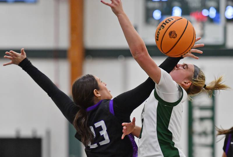 Glenbard West’s Nina Hendricksen (right) is fouled by Downers Grove North’s Gianna Goodwin during a game on December 4, 2025 at Glenbard West High School in Glen Ellyn.