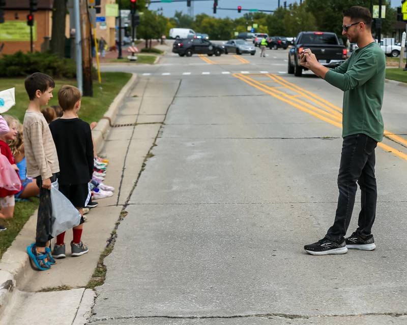 Joel Garrett takes pictures of his sons Daxton and Lenix at the Glenbard West Homecoming Parade.  Sept 16, 2023