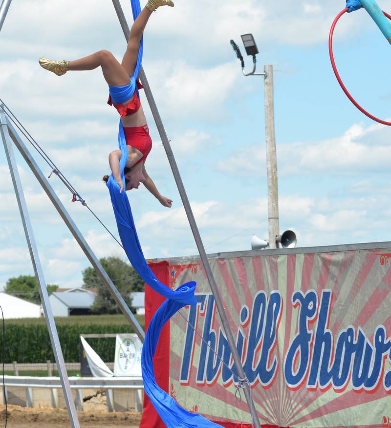 A performer with the Cincinnati Circus Thrill Show is upside down during her aerial act at the Lee County Fair on Sunday, July 30, 2023.