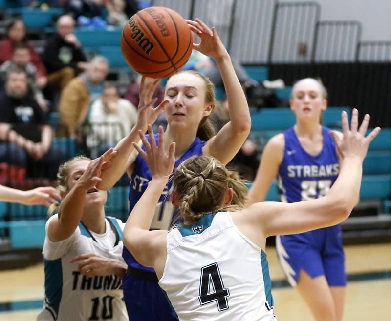 Woodstock's Lily Novelle passes the ball as she tries to drive to the basket between Woodstock North’s Addison Rishling (left)  and Caylin Stevens during a Kishwaukee River Conference girls basketball game on Friday, Jan. 5. 2024, at Woodstock North High School.