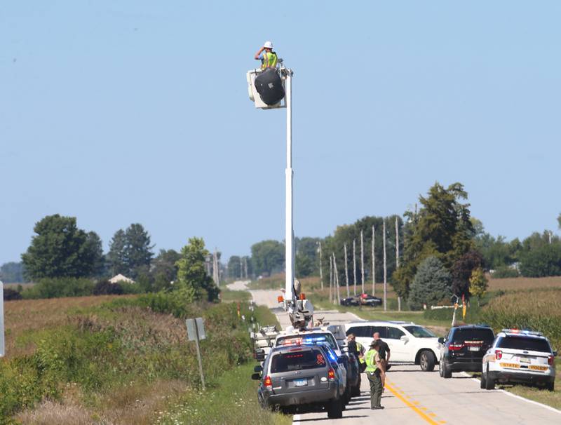 An AT&T worker helps authorities while using binoculars to try to locate a missing juvenile male along East 15th Road near Wallace Grade School on Wednesday, Aug. 30, 2023 north of Ottawa. Wallace Fire Department, Illinois State Police and Ottawa Police Department were called to the school shortly after a student who ran ran out of the school and into a cornfield.