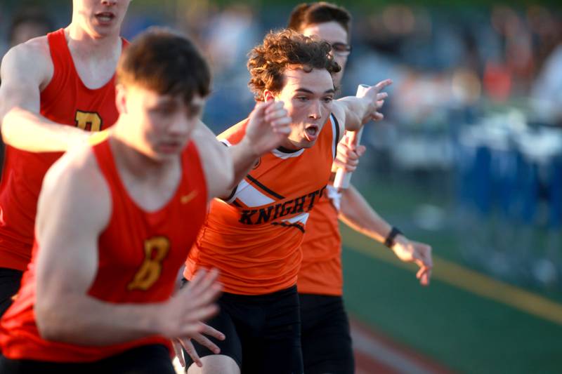 Kaneland’s Benjamin Karl gets the handoff from teammate Alex Moos in the 4x200-meter relay during the Kane County boys track and field championships on Friday, May 9, 2025 at St. Charles North.