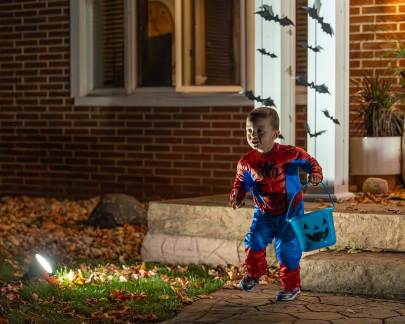 Child runs from house after getting candy from house on Friday, October 31, 2025 on Hopkins Ave. in Granville.