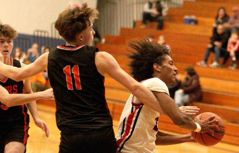 Huntley’s Omare Segarra slips past Crystal Lake Central’s Preston Mast during tournament basketball action at Johnsburg High School Monday evening.
