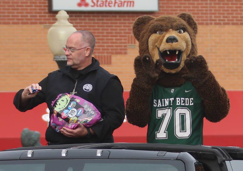 St. Bede Abbot Michael Calhoun throws candy as he rides with th mascot in the St. Bede Homecoming parade on Friday, Sept. 27, 2024 downtown Peru.