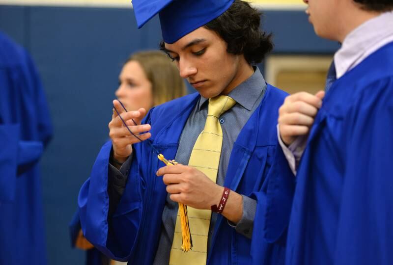 Lyons Township's Andy Garcia of Brookfield prepares to add his tassel to his cap prior to their graduation Wednesday May 25, 2022.