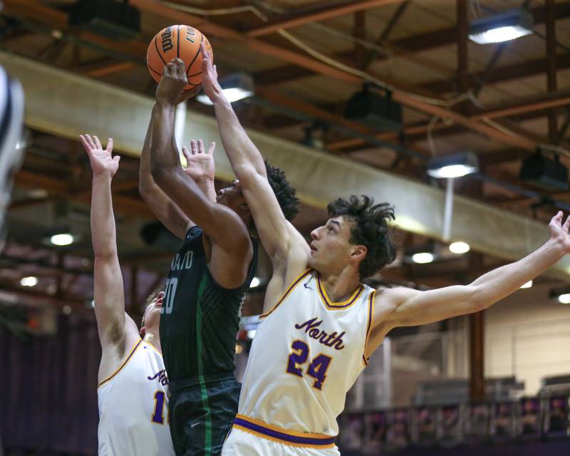 Downers Grove North's Aidan Akkawi (24) blocks a shot by Glenbard West's Logan Glover (20) during their basketball game between Glenbard West at Downers Grove North. Jan 24, 2025 in Downers Grove.
