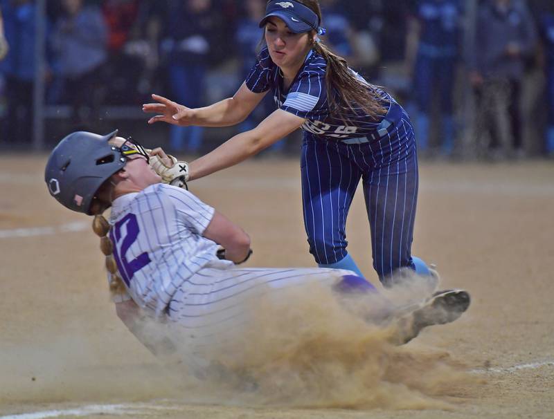 Downers Grove North’s is safe at third base as Downers Grove South third baseman Emily Hines makes a high tag during a game on May 14, 2026 at McCollum Park in Downers Grove .