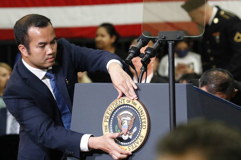 A White House Communications Agency employee affixes the seal of the president of the United States to the podium prior to President Joe Biden's visit to McHenry County College on Wednesday, July 7, 2021 in Crystal Lake.