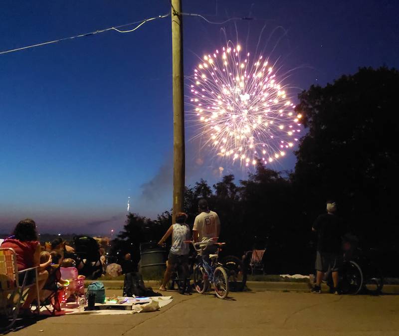 Bicyclists stop to watch the Ottawa Independence Day fireworks Tuesday, July 4, 2023, on Prospect Avenue.