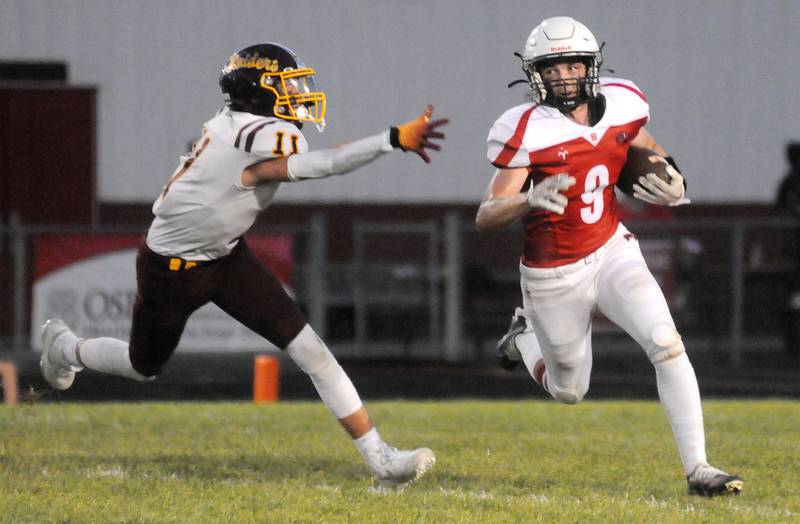 Streator's Jake Hagie runs past the defense of East Peoria's Henry Kaufman at Deiken Stadium on Friday, Aug. 25, 2023.