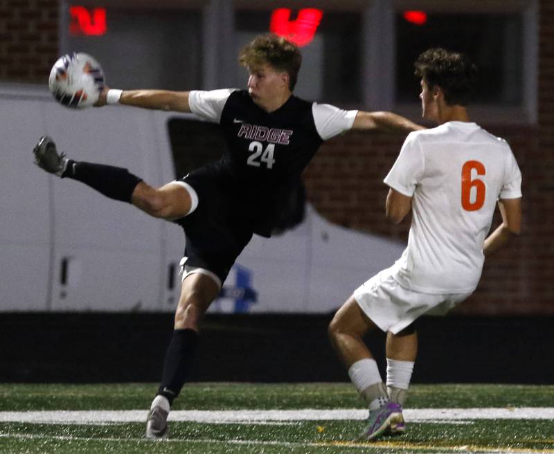 Prairie Ridge's Carter Fredrikson kicks the ball in front of Crystal Lake Central's Nick Pagonis during the IHSA Boys Soccer 2A Grayslake Central Sectional semifinal match on Tuesday, Oct. 29, 2024, at Grayslake Central High School,