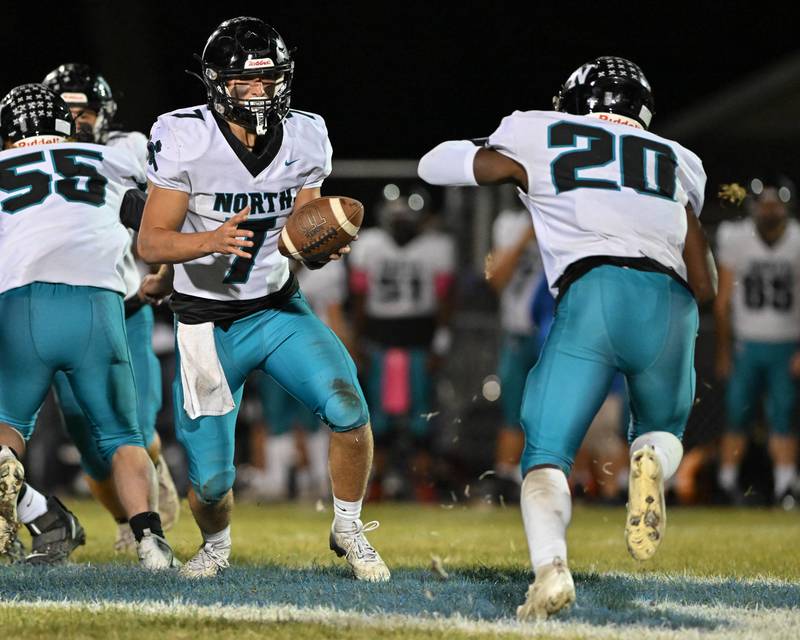 Woodstock North's Parker Halihan looks to hand off the ball early in the first quarter of their game against Kishwaukee River Conference and crosstown rival Woodstock on Friday, Oct. 25, 2024 at Woodstock H.S.
