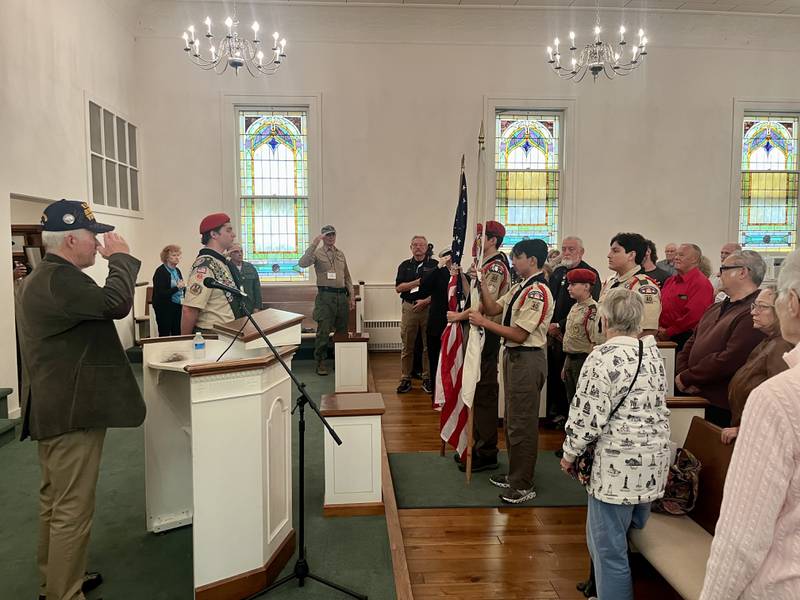 Veterans speaking at Yorkville's Chapel on the Green's annual Veterans Day Tribute salute the color guard before sharing stories of their experiences in the military service.