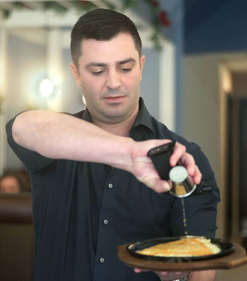 The Flame owner Foti Pappas prepares some saganaki to be fired Friday, Jan. 19, 2024, in the eatery at 209 East Lincoln Highway in DeKalb.  Sagainaki is cheese that is flamed at the table to enhance the dining experience.