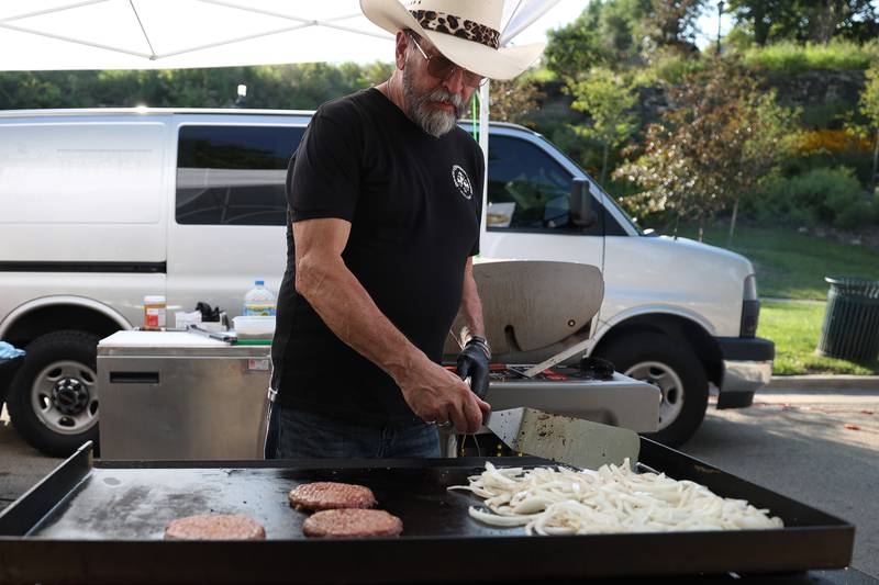 Tom Grotovsky, owner of The Great American Bagel, works the grill at his food tent at the Wine, Jazz and Arts Fest at Bicentennial Park in Joliet on Saturday, Aug. 19, 2023.